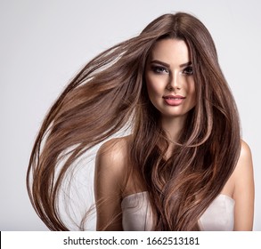 Portrait of a beautiful woman with a long hair. Young  brunette model with  beautiful hair - isolated on white background. Young girl with hair flying in the wind.