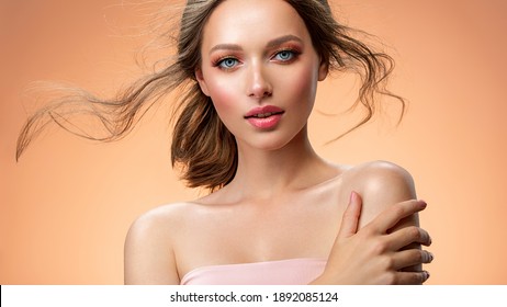 Portrait Of A Beautiful Woman With A Long Hair. Model With Beautiful Hair - Isolated On Beige Background. Young Girl With Hair Flying In The Wind. Beige Eye Makeup With A Long False Black Eyelashes.