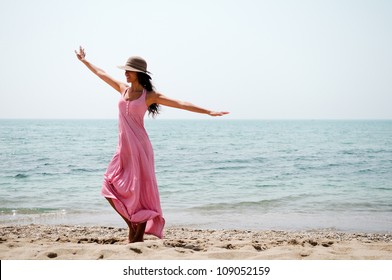Portrait Of A Beautiful Woman With Long Pink Dress On A Tropical Beach