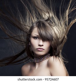 Portrait of a beautiful woman with long straight hair developing on a black background