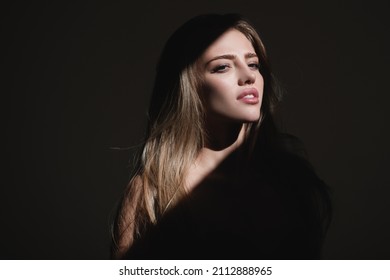 Portrait Of Beautiful Woman Model Looking Seductive And Sensual. Beauty Face With Dramatic Studio Light Isolated On Black. Sensual Girl.