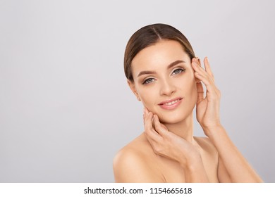 Portrait Of Beautiful Woman With Natural Make Up Touching Her Face. Beauty Young Woman With Fresh Clean Perfect Skin. Skin Care Concept. Cosmetology, Beauty And Spa. Facial Treatment. Natural Skin.