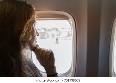 Portrait The Beautiful Woman On The Plane Looking Out Of The Window