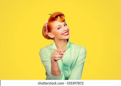 portrait of a beautiful woman pinup retro style pointing at you smiling laughing isolated yellow background wall. Body language, gestures, psychology.