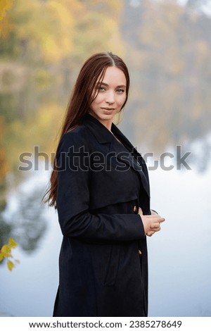 Portrait of a beautiful woman posing near a lake