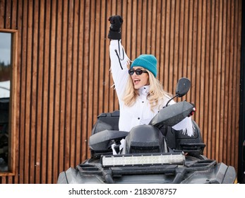 Portrait Of Beautiful Woman Posing On Offroad Four-wheeler ATV With Wooden House On Background. Concept Of Active Leisure And Winter Activities.