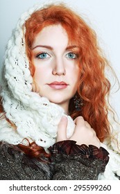 portrait of a beautiful woman with red curly hair in knitted winter clothes