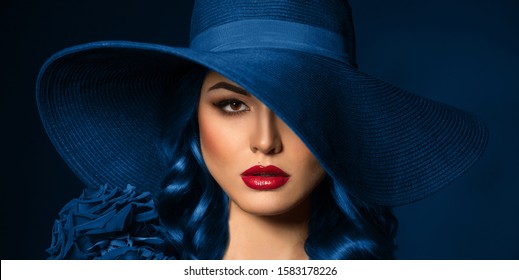 Portrait of a beautiful woman with red lips in a hat, toned in color of the year 2020, classic blue. - Powered by Shutterstock