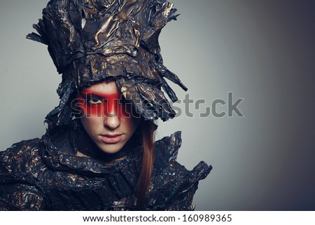 Portrait of beautiful woman with red make-up with metal head-wear