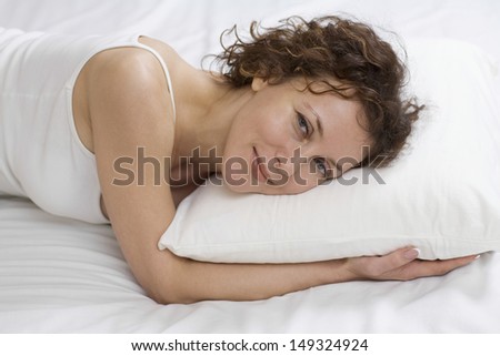 Portrait of beautiful woman relaxing on bed at home