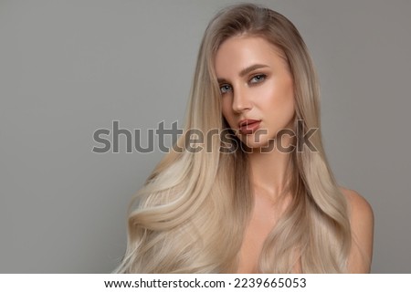 Portrait of a beautiful woman with shiny curly hair. Coloring blond