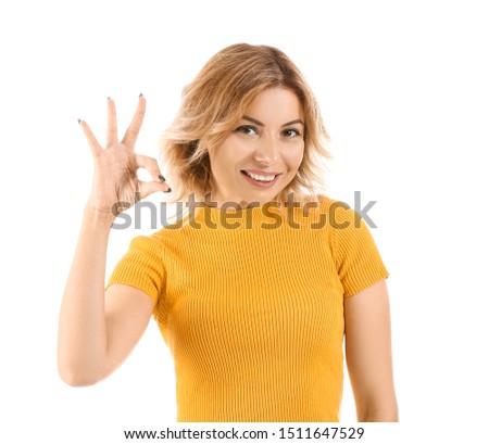 Portrait of beautiful woman showing OK on white background