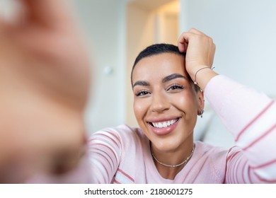 Portrait of a beautiful woman smiling at home. African American woman in casual looking at camera with copy space. Cheerful mixed race girl relaxing at home with big laugh.
