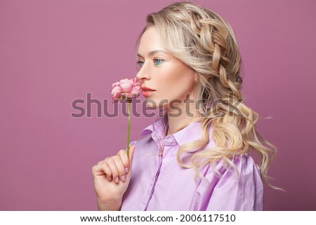 Portrait of beautiful woman with spring flower on pink banner background, profile