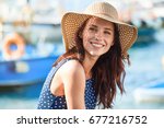 Portrait of a beautiful woman in a straw hat. Laughing girl. Summer time