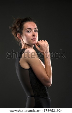 Similar – Close up front upper body portrait of one young athletic woman in sportswear in gym over dark background, looking at camera