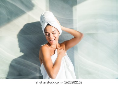 Portrait of beautiful woman wearing bathrobe and towel on head after shower - Powered by Shutterstock