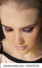 Portrait Of Beautiful Woman Wearing Edgy Makeup With Purple Sparkle Eyeshadow  And Dark Eyeliner. 