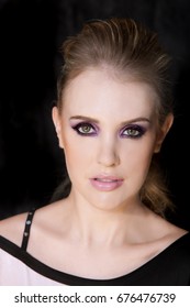 Portrait Of Beautiful Woman Wearing Edgy Makeup With Purple Sparkle Eyeshadow  And Dark Eyeliner. 