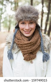 Portrait of a beautiful woman wearing fur hat with woolen scarf and jacket in the woods