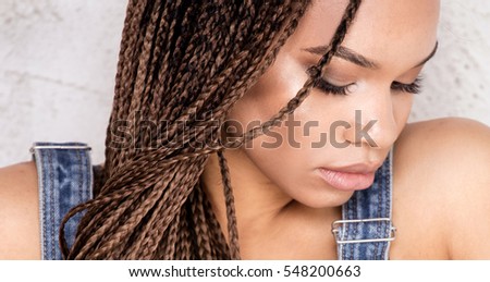 Portrait of beautiful young african girl with braids, studio shot.