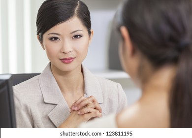 Portrait of a beautiful young Asian Chinese woman or businesswoman in office meeting with female colleague - Shutterstock ID 123811195