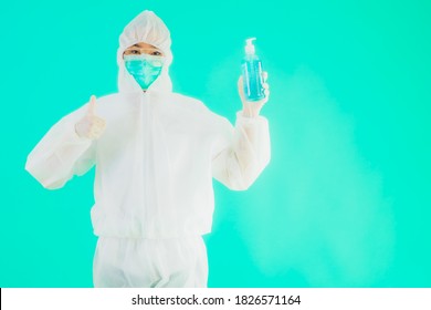 Portrait Beautiful Young Asian Doctor Woman Wear Ppe Suite And Mask With Alcohol Gel On Blue Isolated Background