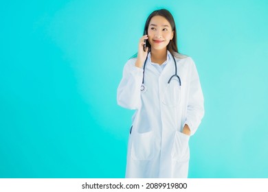 Portrait Beautiful Young Asian Doctor Woman Use Mobile Smart Cell Phone For Clinic Or Hospital On Blue Isolated Background