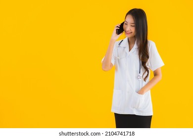 Portrait Beautiful Young Asian Doctor Woman Use Smart Mobile Cell Phone On Yellow Isolated Background