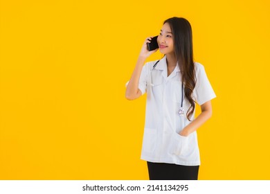 Portrait Beautiful Young Asian Doctor Woman Use Smart Mobile Cell Phone On Yellow Isolated Background