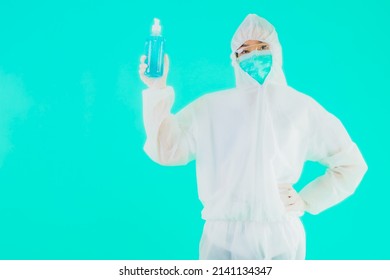 Portrait Beautiful Young Asian Doctor Woman Wear Ppe Suite And Mask With Alcohol Gel On Blue Isolated Background