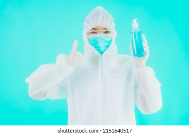 Portrait Beautiful Young Asian Doctor Woman Wear Ppe Suite And Mask With Alcohol Gel On Blue Isolated Background