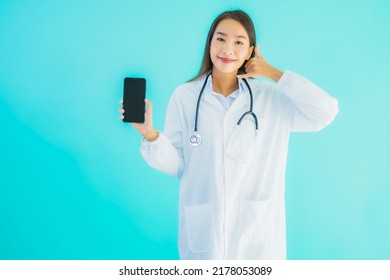 Portrait Beautiful Young Asian Doctor Woman Use Mobile Smart Cell Phone For Clinic Or Hospital On Blue Isolated Background