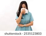 Portrait of beautiful young asian sick woman being wrapped in scarf sneezing, suffering from runny nose and high temperature. Cold and fever concept.