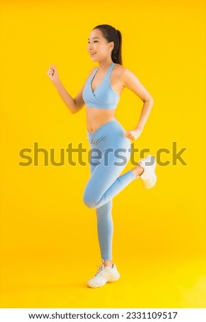 Portrait beautiful young asian sport woman with sportwear ready for exercise on yellow isolated background