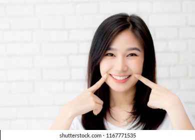 Portrait of beautiful young asian woman happiness standing finger touch cheek on gray cement texture grunge wall brick background, businesswoman is a smiling on concrete, business people concept. - Shutterstock ID 1167771535