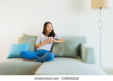 Portrait beautiful young asian woman on sofa with coffee cup and relax - Shutterstock ID 1558102226