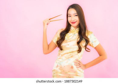 Portrait beautiful young asian woman with chopsticks on pink background
