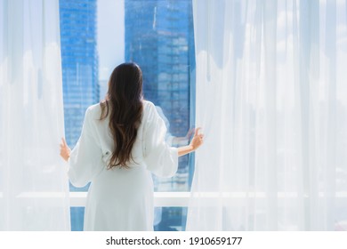 Portrait Beautiful Young Asian Woman Open Curtain Window And Look Outside Of Window For The View