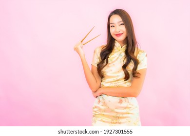 Portrait beautiful young asian woman with chopsticks on pink background