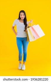 Portrait Beautiful Young Asian Woman With Colorful Shopping Bag On Yellow Isolated Background