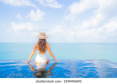 Portrait beautiful young asian woman relax smile leisure around outdoor swimming pool with sea ocean in travel vacation