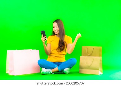 Portrait Beautiful Young Asian Woman With Colorful Shopping Bag And Mobile Phone On Green Background