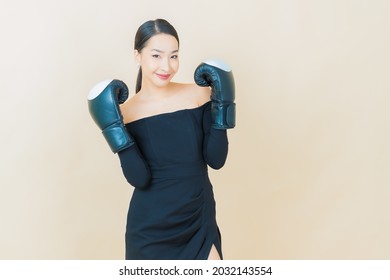 Portrait beautiful young asian woman boxing with glove on color background