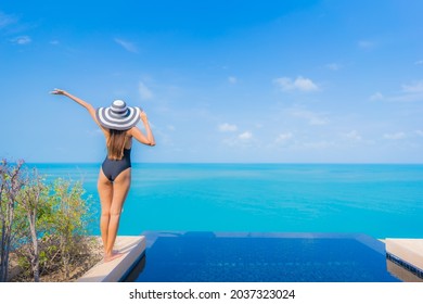 Portrait beautiful young asian woman relax smile leisure around outdoor swimming pool in resort hotel with sea ocean view