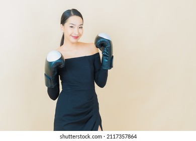 Portrait beautiful young asian woman boxing with glove on color background