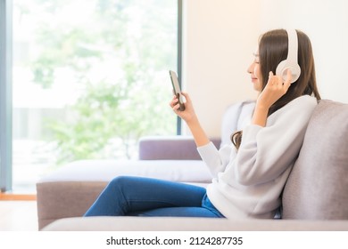 Portrait Beautiful Young Asian Woman Use Smart Mobile Phone Headphone For Listen Music In Living Room