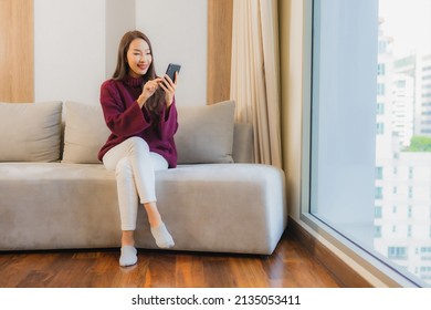 Portrait beautiful young asian woman use smart mobile phone on sofa in living room interior - Shutterstock ID 2135053411