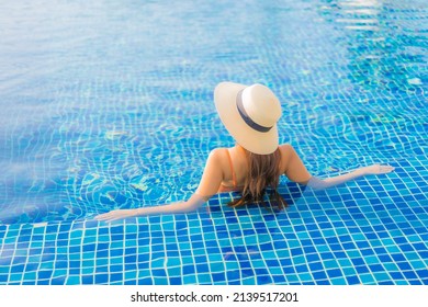 Portrait beautiful young asian woman relax smile leisure around outdoor swimming pool in resort hotel with sea ocean view - Shutterstock ID 2139517201