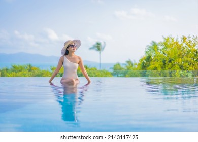 Portrait beautiful young asian woman enjoy around outdoor swimming pool with sea ocean view in travel vacation trip - Powered by Shutterstock